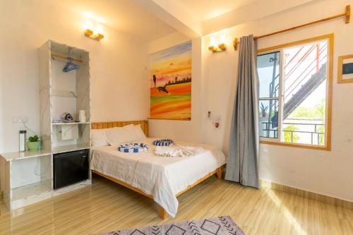 a bedroom with a bed and a window at Olhumathi View Inn in Ukulhas
