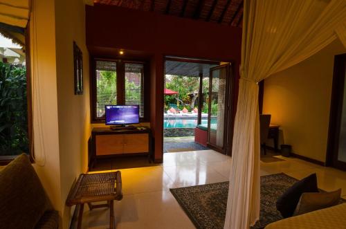 a living room with a television and a pool at Imani Villas in Canggu
