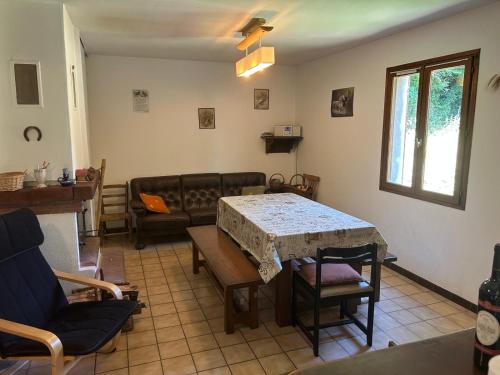ein Wohnzimmer mit Tisch und Couch in der Unterkunft Maison de Vacances in Pradelles-Cabardès