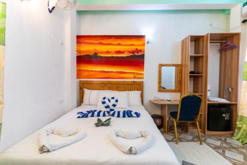 a bedroom with a bed with a painting on the wall at Olhumathi View Inn in Ukulhas