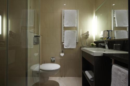 a bathroom with a toilet and a sink and a shower at IntercityHotel Mannheim in Mannheim
