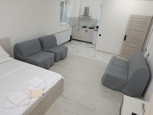 a bedroom with a bed and a couch and chairs at Max Night Dreams in Bucharest