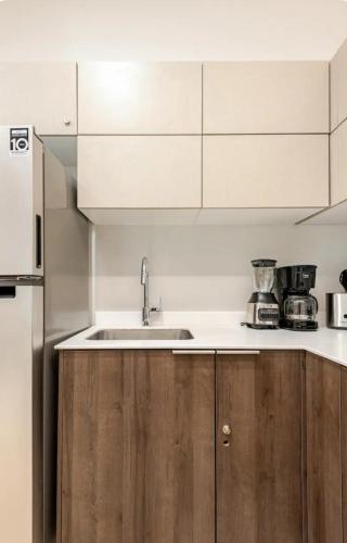 a kitchen with white cabinets and a sink at Hotel zone - Private Jacuzzi & Free Beach Club in Tulum
