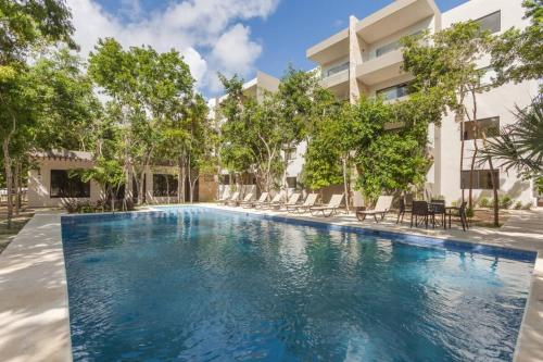 a swimming pool in front of a building at FamilyFriendly10min to BeachWIFI200MB6PoolsGym in Playa del Carmen