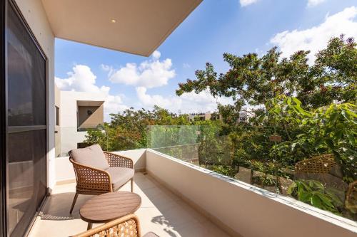 a balcony with two chairs and a table at FamilyFriendly10min to BeachWIFI200MB6PoolsGym in Playa del Carmen