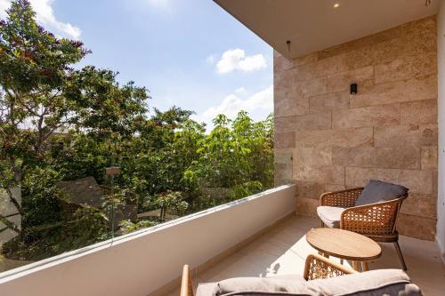 a balcony with two chairs and a table at FamilyFriendly10min to BeachWIFI200MB6PoolsGym in Playa del Carmen