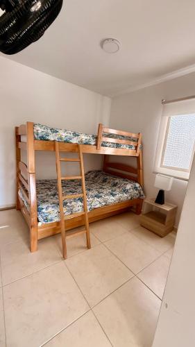 two bunk beds in a room with a window at Apartamento en el Eje Cafetero-Aire acondicionado, piscinas, BBQ in La Tebaida