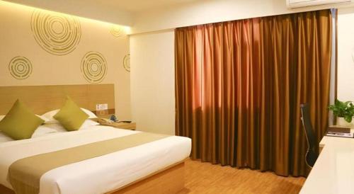 Ένα ή περισσότερα κρεβάτια σε δωμάτιο στο GreenTree Inn High-tech Zone Shandong University Bathing Beach Hotel
