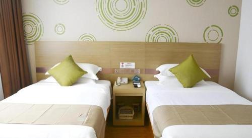 Ένα ή περισσότερα κρεβάτια σε δωμάτιο στο GreenTree Inn High-tech Zone Shandong University Bathing Beach Hotel