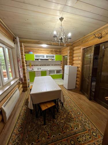 ein Esszimmer mit Tisch und Kühlschrank in der Unterkunft Ene sai in Karakol