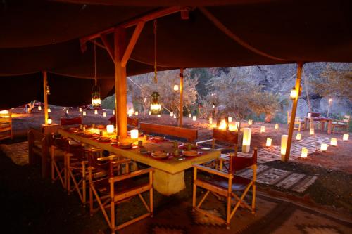 a long table with candles and chairs under a tent at Ma'in Hot Springs in Sowayma