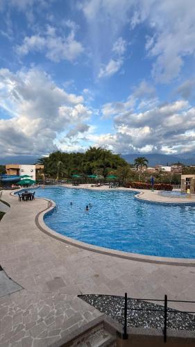 a large swimming pool with people swimming in it at Apartamento en el Eje Cafetero-Aire acondicionado, piscinas, BBQ in La Tebaida