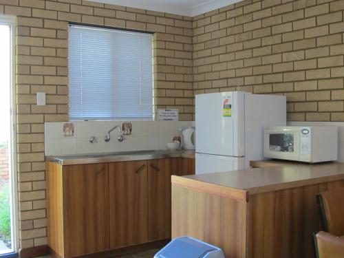a kitchen with a white refrigerator and a sink at Ocean View Villas in Geraldton