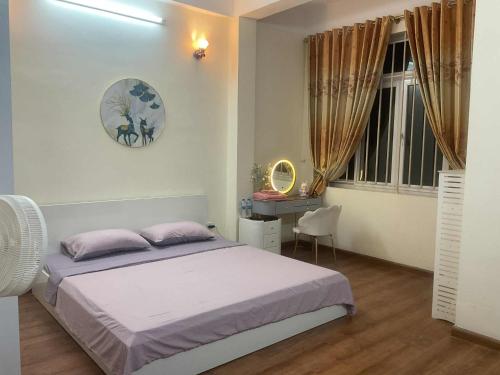 a bedroom with a bed and a desk and a window at Ribi Home in Hà Ðông