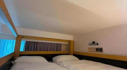 two beds in a room with a window at Harbour Bay Hotel in Hong Kong