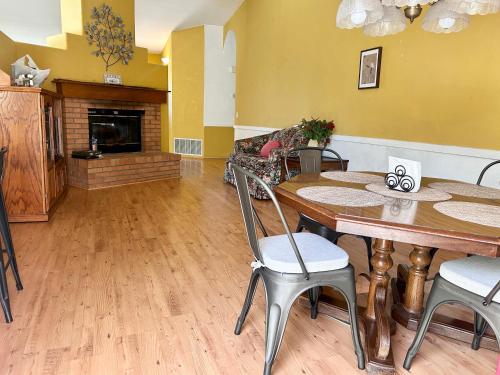 a dining room with a table and a fireplace at Rosewood Retreat in Hemet