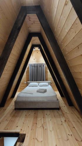 a bed in the middle of a room in a attic at Vila Alpine Arlon Gjinar in Gjinar