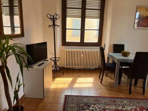 sala de estar con mesa, TV, mesa y sillas en Appartamento Porretta Sweet Soul, en Porretta Terme