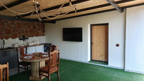 a room with a table with chairs and a television at Khachatryan's Guest House in Yeghegnadzor