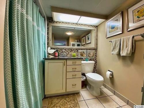 a bathroom with a toilet and a sink and a mirror at Ocean View, Near Boardwalk, Pool, Hot Tub in Myrtle Beach