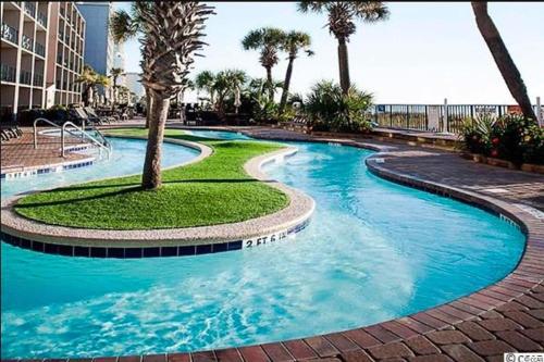 a swimming pool with a palm tree in the middle at Ocean View, Near Boardwalk, Pool, Hot Tub in Myrtle Beach
