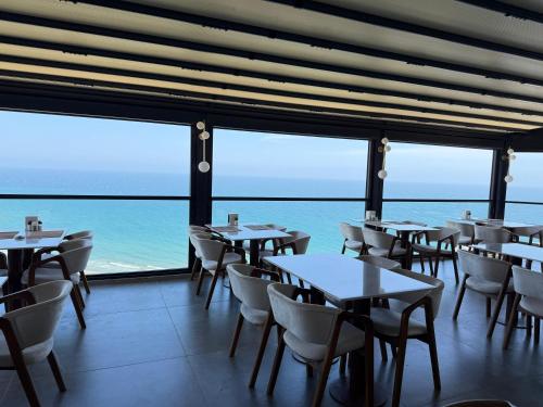 a restaurant with tables and chairs and a view of the ocean at CLASS PREMİUM hotel in Çanakçılar
