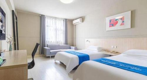 a hotel room with two beds and a couch at Jinjiang Inn Weihai High Speed Qingdao South Road in Weihai
