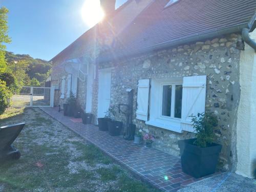a stone house with a window and potted plants at Pause Campagne 1 