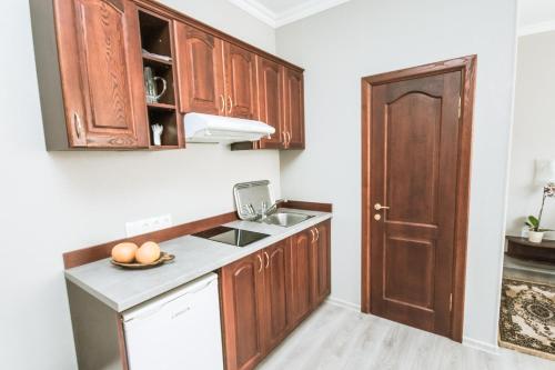 a kitchen with wooden cabinets and a sink at Hotel Kert FREE PARKING in Rīga