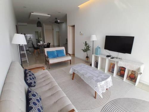 a living room with a couch and a flat screen tv at Condominium Crystal Heights in Taiping