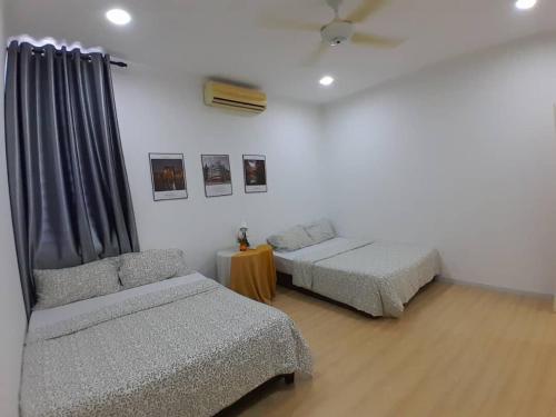 a room with two beds and a couch and a table at Condominium Crystal Heights in Taiping