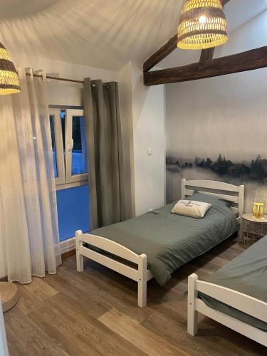 a bedroom with two beds and a window at L escale des dhuys in Soulaines-Dhuys