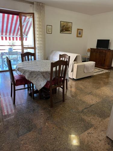 Una sala de estar con una mesa y sillas y un sofá. en La casa di Paola, en San Benedetto del Tronto