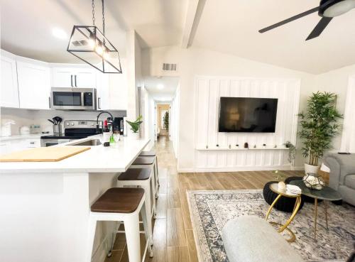 a kitchen with white cabinets and a living room at cozy home in Tampa near Ybor & Busch Gardens in Tampa