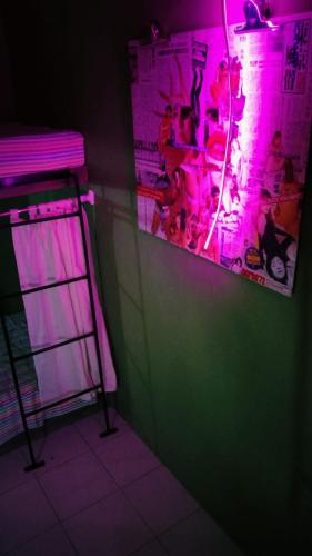 a room with a green wall and purple lights at Abrakadabra Manshon in Timuran