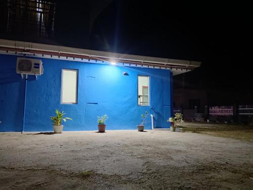 a blue building with a light on it at night at Homestay Impian Bapa in Semporna