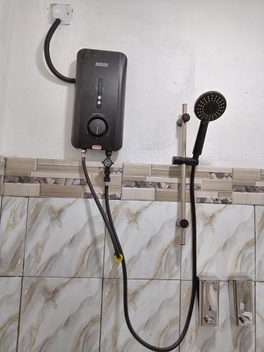 a hair dryer is attached to a wall at Homestay Impian Bapa in Semporna
