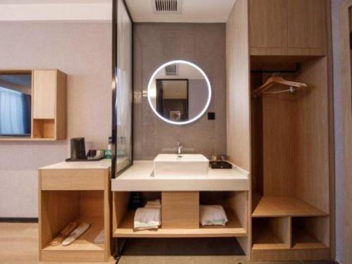 ein Badezimmer mit Waschbecken und Spiegel in der Unterkunft GreenTree Inn Bengbu Huaihe Walking Street in Bengbu