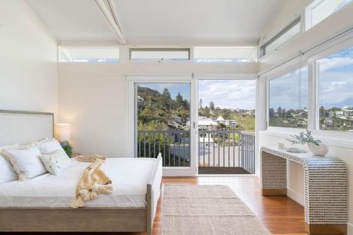 a bedroom with a bed and a large window at The Bungan - Beachfront W Access To Bungan Beach in Newport