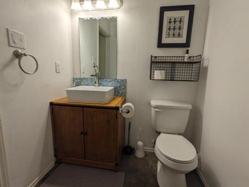 Un baño con un inodoro blanco y un lavabo. en Urbenity, en Irving