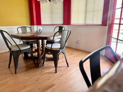 a dining room with a table and four chairs at Peach Blossom Country House in Hemet