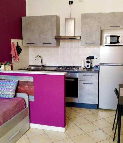 a kitchen with a pink island in a kitchen at La Casetta Monza Park in Vedano al Lambro