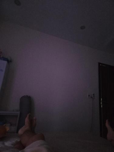 a person laying on a bed watching a tv at Back ally beach house in Dong Hoi