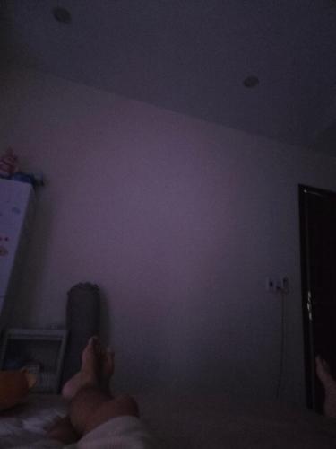 a person laying on a bed in a dark room at Back ally beach house in Dong Hoi