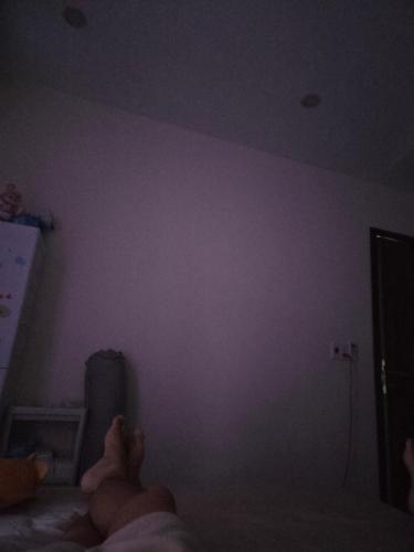 a person laying on a bed in a dark room at Back ally beach house in Dong Hoi
