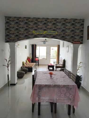a living room with a table with a pink table cloth at Green Tea View in Munnar