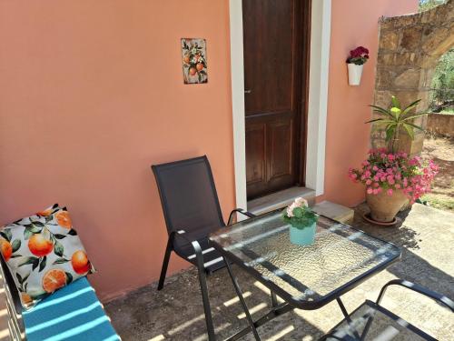 a patio with a glass table and a chair at Terra Solaris Guesthouse in Kissamos