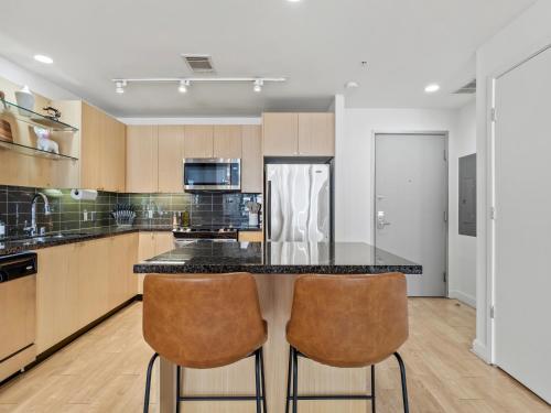 a kitchen with a counter and two bar stools at City View Downtown Dallas High Rise Condo with Free Parking, Gym, Pool in Dallas