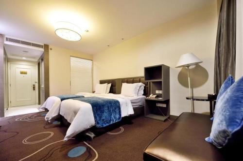 a hotel room with two beds and a couch at Jinjiang Metropolo Hotel Classiq YMCA People Square in Shanghai