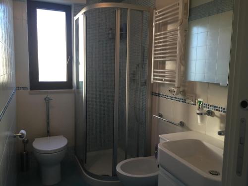 uma casa de banho com um chuveiro, um WC e um lavatório. em Attico Fronte Mare em Pozzallo